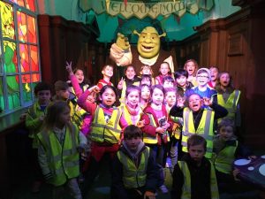 Children posing in front of a Shrek Statue