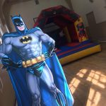 Batman poster in front of a Marvel Themed Bouncy castle