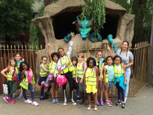 Kids posing in front of a dragon staute