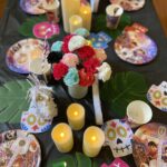 Coco themed kids' party tablescape with vibrant Marigold flowers, colorful papel picado banners, and a festive table setting featuring bright plates, themed cups, and elegant tableware for a luxurious celebration
