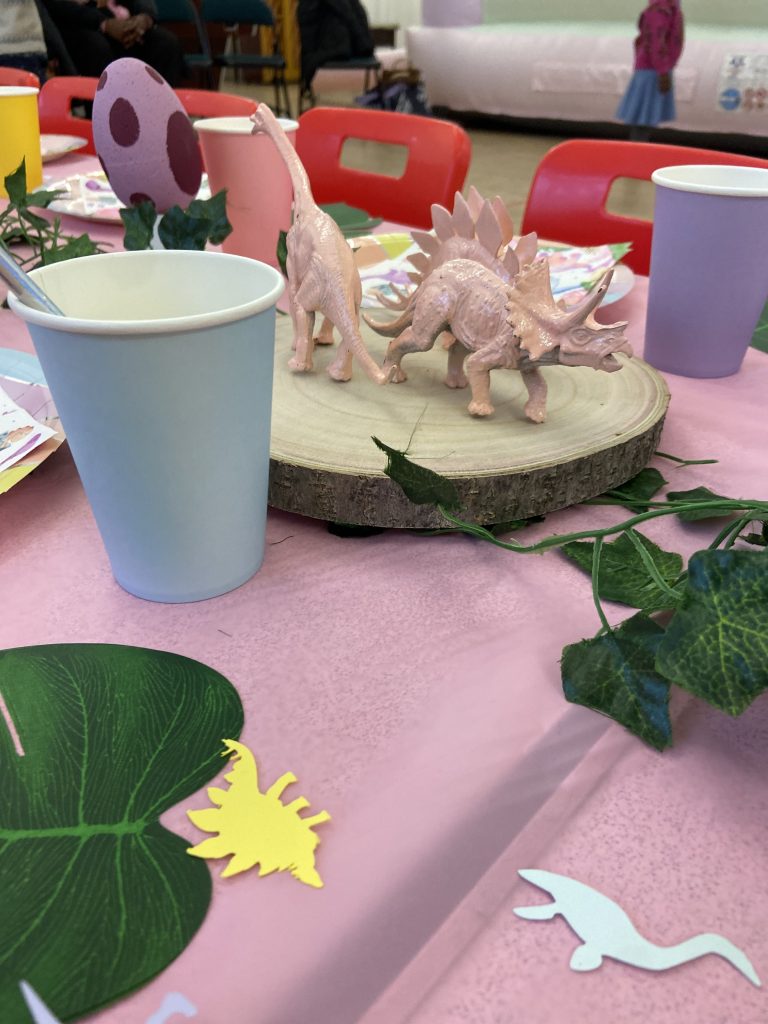 Kids party table for a girls birthday party, with a theme of prehistoric princess.